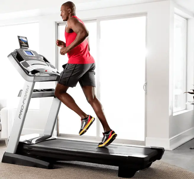 Man in red tank top and black shorts running in a Proform Pro 2000 treadmill