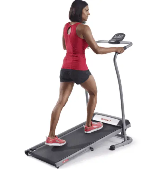 Woman in red top and black short running in a Weslo cadence r 5.2 treadmill