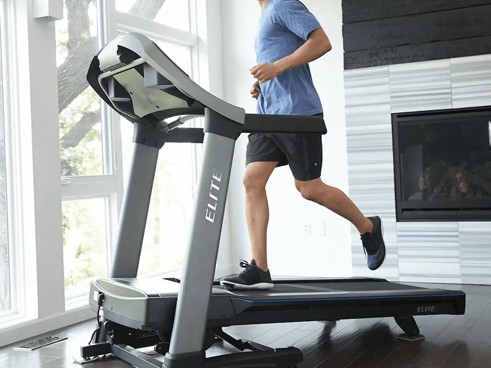 Man wearing blue shirt and black short while running in a Horizon Elite T9-02 Treadmill for Home