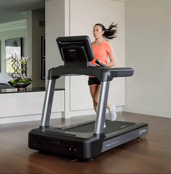 Girl wearing top and black shorts running in a life fitness treadmill